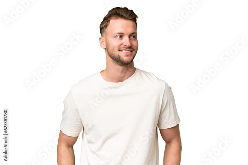 Young blonde caucasian man over isolated background thinking an idea while looking up