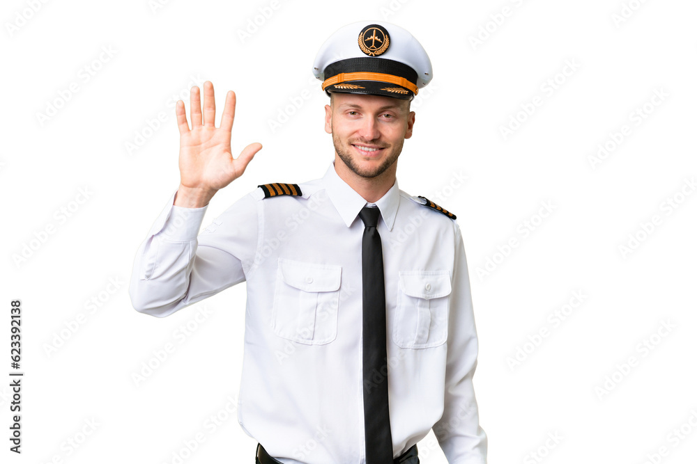 Airplane pilot man over isolated background saluting with hand with happy expression