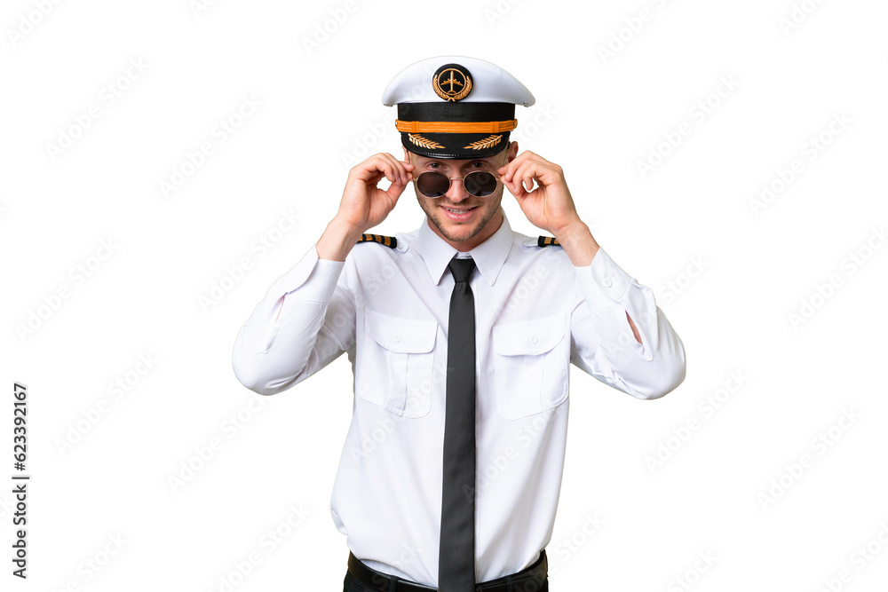 Airplane pilot man over isolated background with glasses and surprised