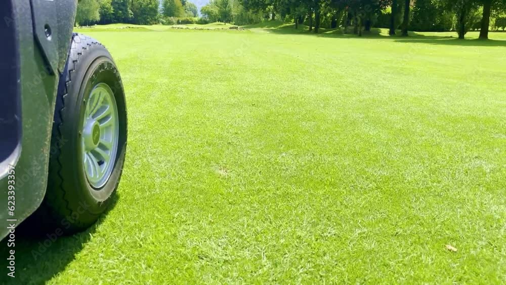 Low Angle View on a Golf Cart Travel on the Fairway on Golf Course in a Sunny Summer Day in Switzerland.