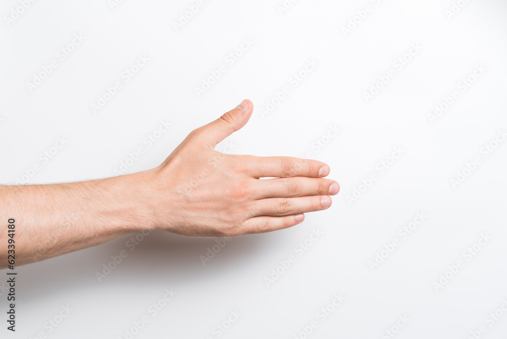 Close-up of a man's hand. He stretches out his hand for a handshake gesture on a white background.