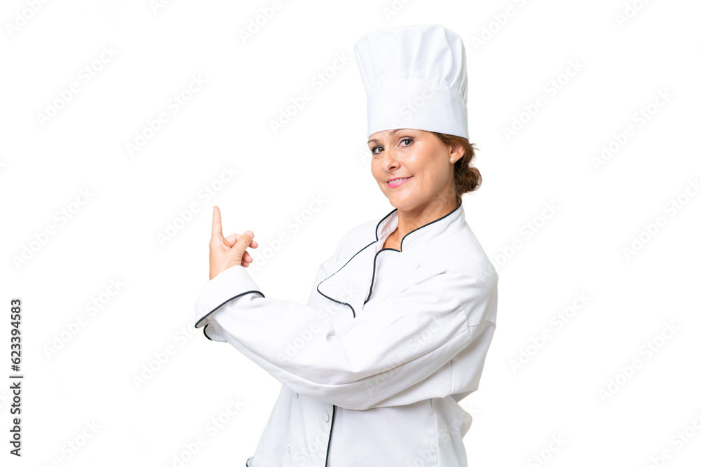 Middle-aged chef woman over isolated background pointing back Middle-aged chef woman over isolated background pointing back