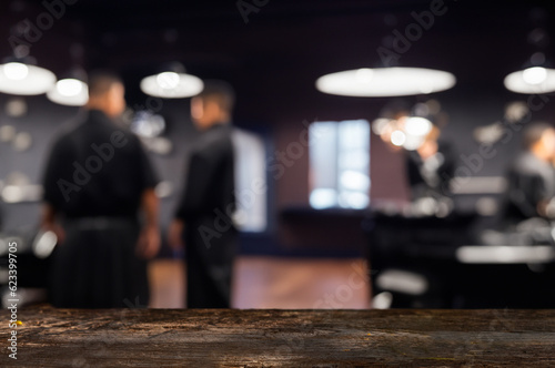 Space for ads and decoration on wooden table, blurry view of barber shop. © MAXSHOT_PL