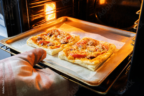 Chef taking out from oven delicious homemade pizza