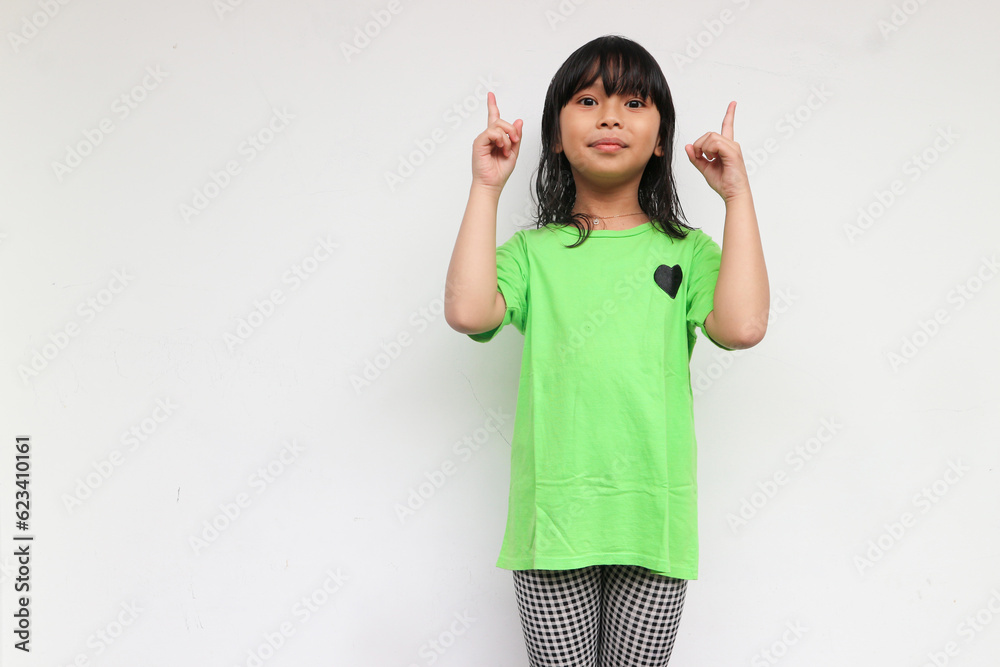 A smiling kid girl raised her hands to pointing side for show something A smiling kid girl raised her hands to pointing side for show something