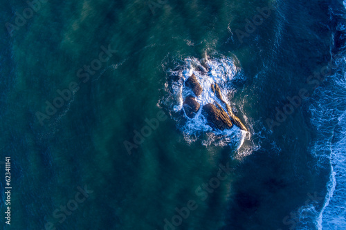 Fototapeta overhead aerial view of rocks near the coast in the atlantic ocean