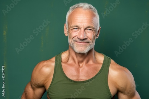 Close-up portrait photography of a glad mature man wearing a stylish tank top against a green background. With generative AI technology