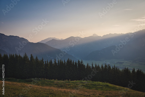Trees in front of a mountain range at dawn near Saalfelden in Austria
