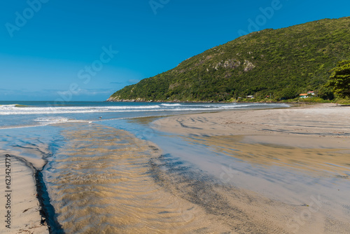 Sunny day at Matadeiro beach with mountains and ocean in Florianopolis. photo