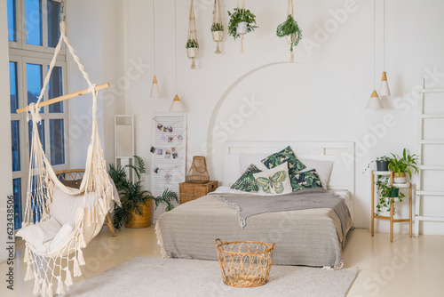 Cozy rustic bedroom with boho ethnic decor.Plants in the interior.