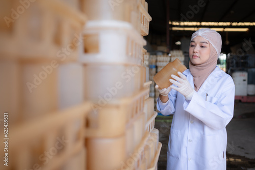 Portrait of a young scientist working in a laboratory She is examining the mushroom culture bottles in the mushroom house.
