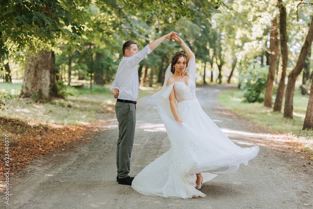 A wedding couple, a happy bride and groom are running in the park to the place of the wedding ceremony. Wedding concept A wedding couple, a happy bride and groom are running in the park to the place of the wedding ceremony. Wedding concept