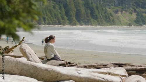 Woman on serene Beach Looking Out Over the Ocean, Surfer Walks with Surfboard