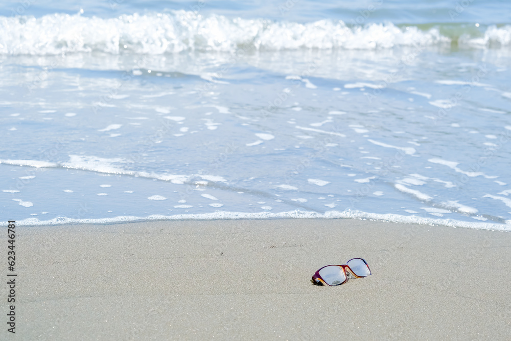 Obraz premium 砂浜に忘れられたメガネ