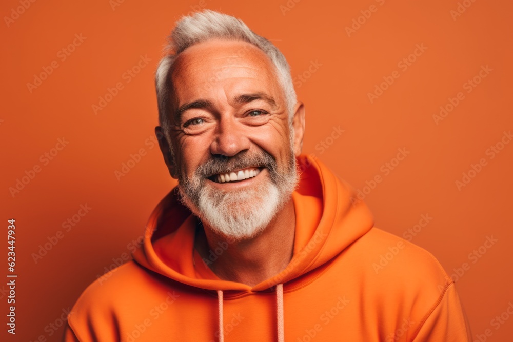 Headshot portrait photography of a joyful mature man wearing a comfortable hoodie against a pastel orange background. With generative AI technology Headshot portrait photography of a joyful mature man wearing a comfortable hoodie against a pastel orange background. With generative AI technology