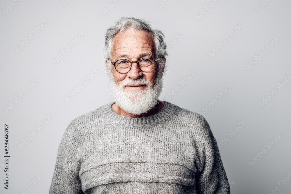 Obraz premium Environmental portrait photography of a glad old man wearing a cozy sweater against a pearl white background. With generative AI technology