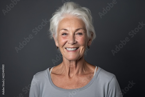 Headshot portrait photography of a satisfied old woman wearing a cute crop top against a cool gray background. With generative AI technology © Markus Schröder