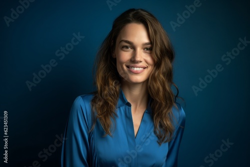 Medium shot portrait photography of a grinning girl in her 30s wearing an elegant long-sleeve shirt against a sapphire blue background. With generative AI technology