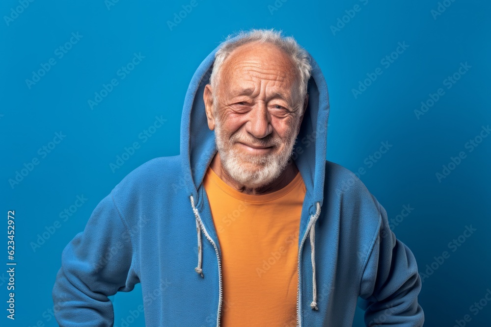 Studio portrait photography of a joyful old man wearing a cozy zip-up hoodie against a periwinkle blue background. With generative AI technology Studio portrait photography of a joyful old man wearing a cozy zip-up hoodie against a periwinkle blue background. With generative AI technology
