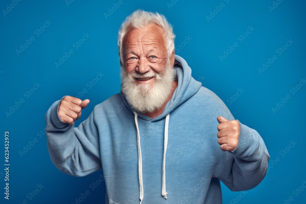 Studio portrait photography of a joyful old man wearing a cozy zip-up hoodie against a periwinkle blue background. With generative AI technology Studio portrait photography of a joyful old man wearing a cozy zip-up hoodie against a periwinkle blue background. With generative AI technology