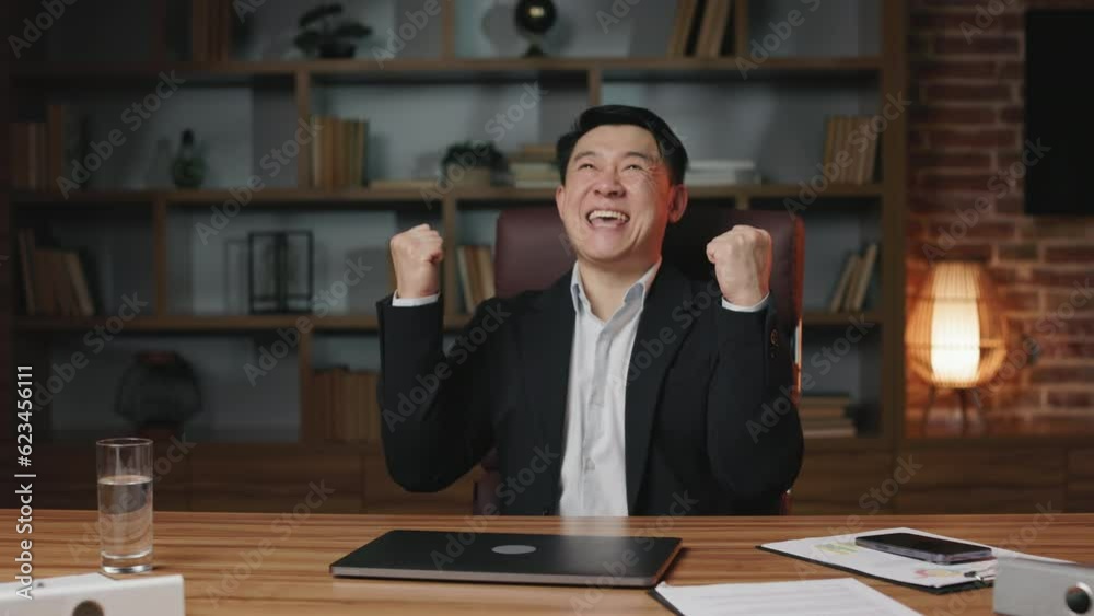 Formally dressed asian gentleman finishing work and closing portable laptop. Cheerful business person feeling satisfied with work results, leaning on chair with clenched fists and shouting yes. Formally dressed asian gentleman finishing work and closing portable laptop. Cheerful business person feeling satisfied with work results, leaning on chair with clenched fists and shouting yes.