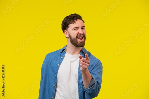 Fotografi Adult man smiling, winking and pointing his finger at the camera