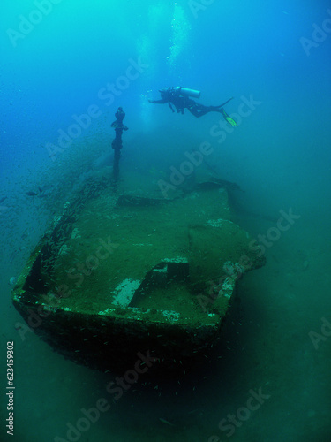 a diver exploring a small sunken ship in the caribbean sea