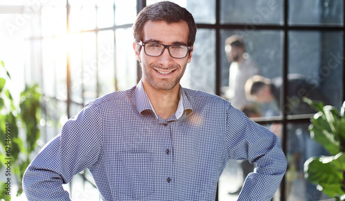 Young businessman in casual clothes stands with his hands on his waist