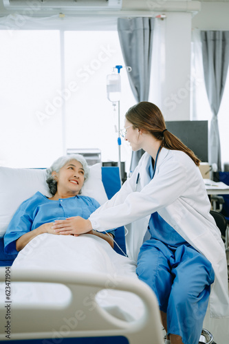  Caucasian doctor smiling take care of a senior patient in hospital. Friendly nurse or therapeutic treat client Professional medical service concept..