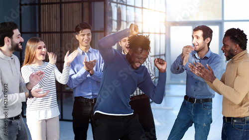 Tela happy excited millennial employees shouting for joy, raising hands for emotional high fives