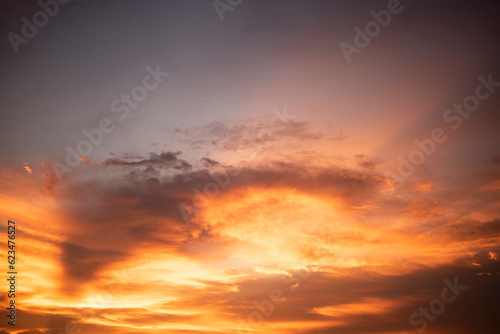 Glowing gold, orange-red, cloudy sky at sunset. Wallpaper concept.