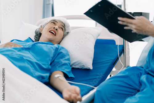 Friendly nurse taking care of elderly woman in a hospital room. Treatment of patients.