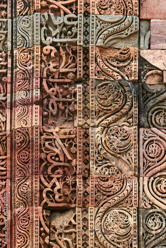 Wall decorative patterns of Qutb complex in South Delhi, India, close up ancient bas relief wall decorations of mosque ruins landmark, popular touristic spot in New Delhi, ancient indian architecture