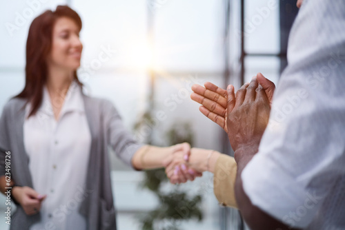 Two Businesswomen Shaking Hands In Modern Office