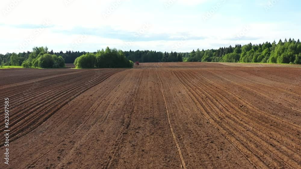 Drone flies low over the arable potato field on sunny spring day, panoramic view Drone flies low over the arable potato field on sunny spring day, panoramic view