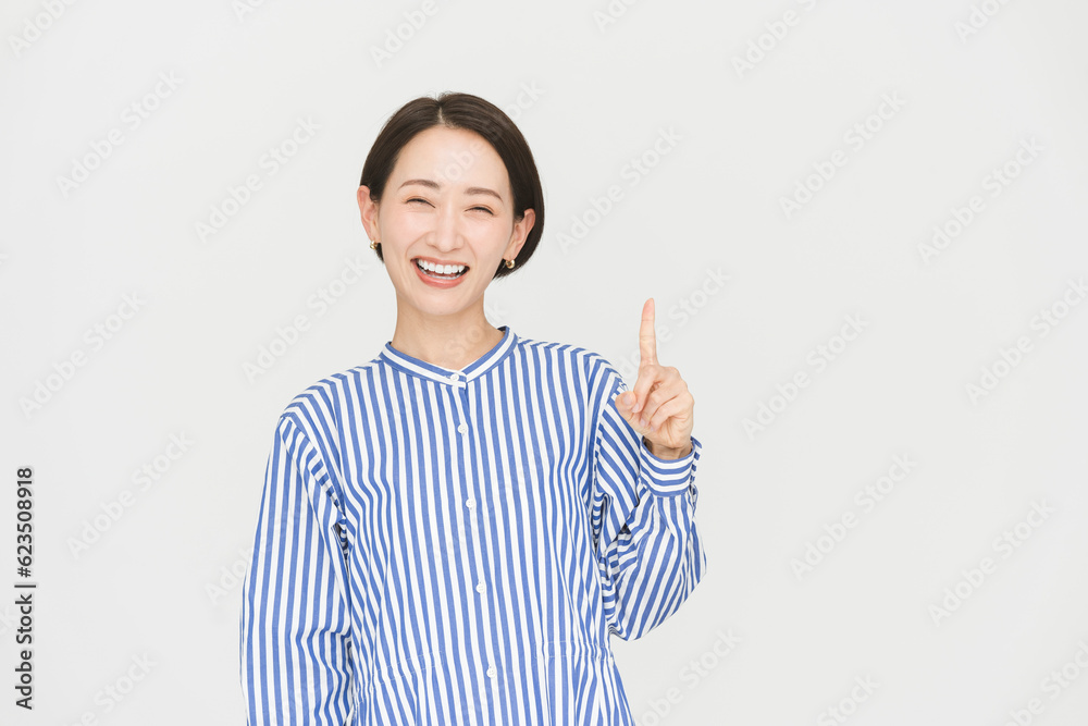 健康的なミドル世代日本人女性/スタジオ撮影白背景/指差し
