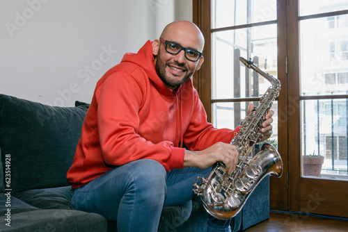 Canvas Print portrait latin musician man at home sitting looking at the camera smiling happy