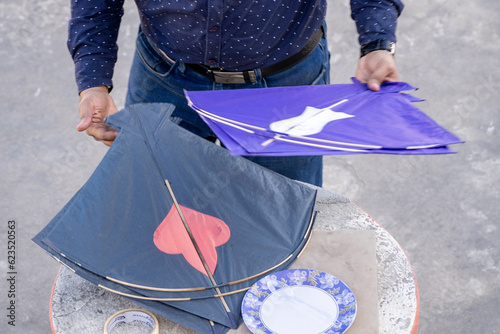 Man preparing kites for flight on makar sankranti uttarayan independence day india showing the celebrations photo
