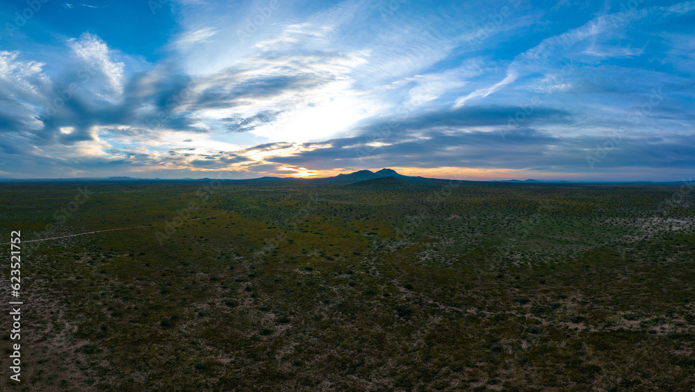 Aerial Serenity of the Verdant Mojave with Sunset Skies and Floating Clouds