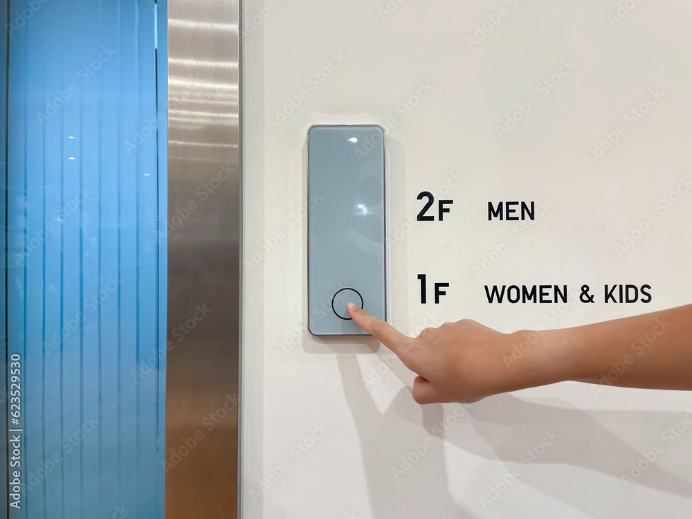 The hand of a young woman pressing the elevator, contactless. The hand of a young woman pressing the elevator, contactless.