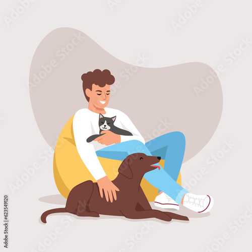 A man sits on a bean bag chair with a cat and a dog