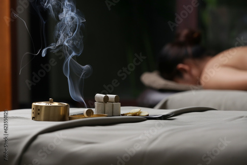 Moxibustion treatment - traditional Chinese medicine tools for acupuncture points heating therapy. Chinese herbal medicine. Moxibustion copper burner box with moxa herbal sticks in holistic spa.