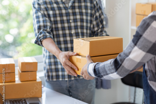 Two men's hands packing things for delivery SME business owner and start-up business © Witoon