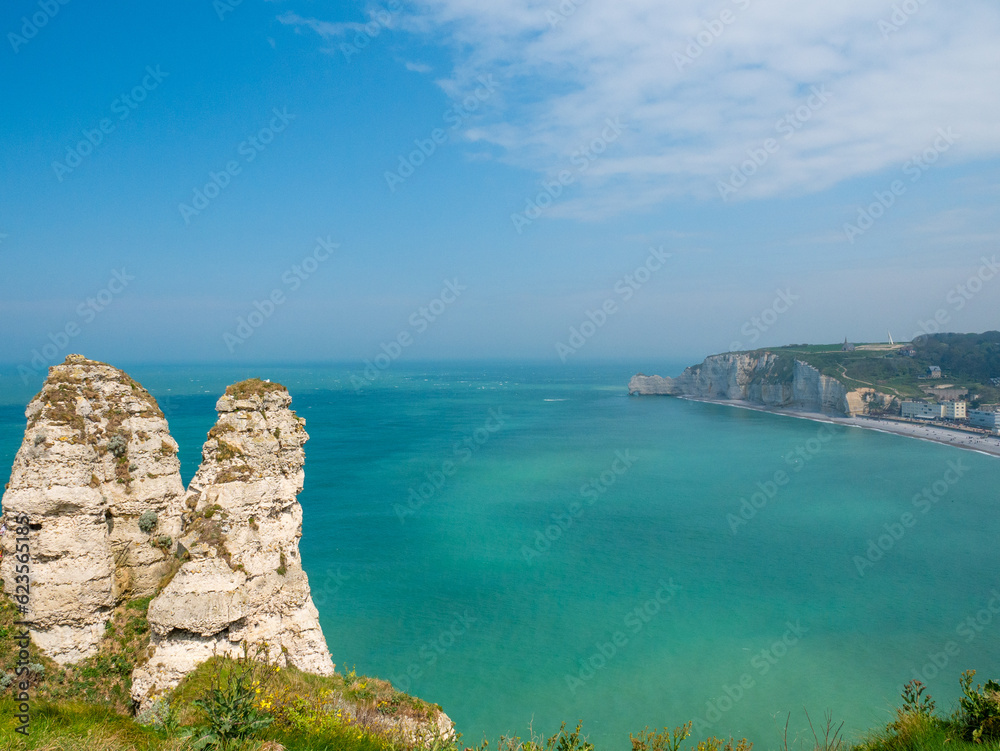 White cliffs of Etretat, Normandy, France,  with stunning view of the emerald sea ( the channel) and the blue sky in the background