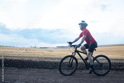 man cyclist rides a bike on a road in nature. sports, cycling and health hobbies