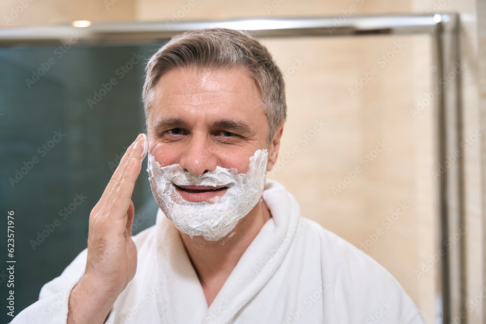 Smiling male about to shave in the hotel