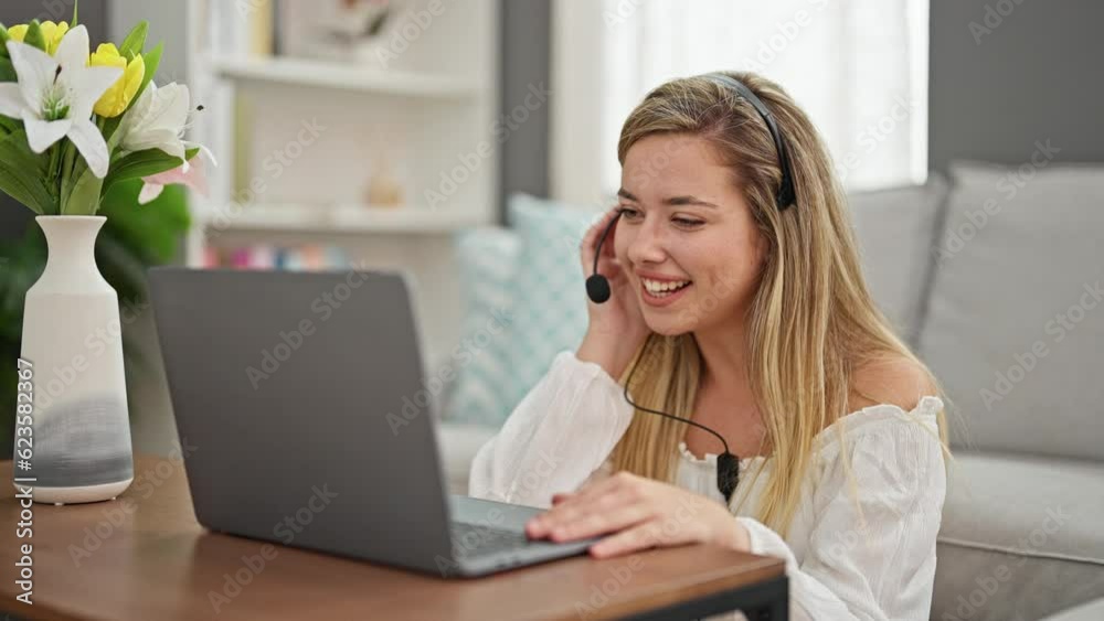 Young blonde woman having video call sitting on floor at home Young blonde woman having video call sitting on floor at home