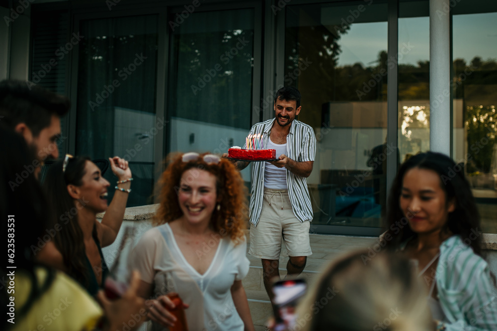 Obraz premium Surprise birthday cake, a group of friends bring out a beautifully decorated birthday cake, surprising one of them.