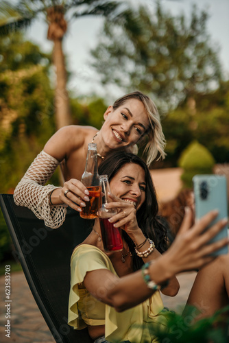 A group of young people exchanges enthusiastic dancing, taking selfies, and hugging each other, with cocktail bottles in hand going to watch a sunset.