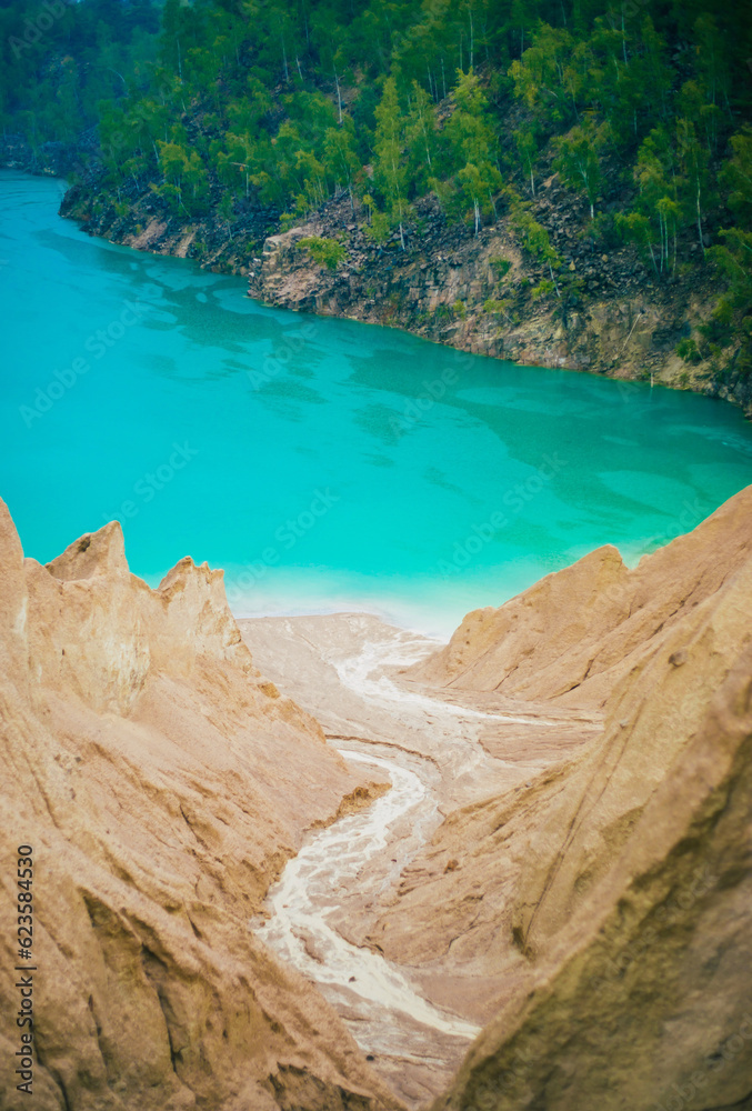 The shores of the mountain lake, the blue water in the lake. Turquoise color lake in a quarry. Place for hiking and relax